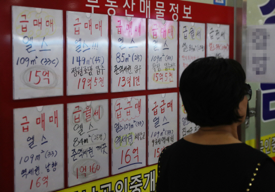 서울 공동주택 공시가격이 11년 만에 가장 많이 오른 가운데 최근 서울 송파구 잠실동의 한 아파트 공인중개업소 매물정보판 앞을 한 시민이 지나가고 있다. 연합뉴스