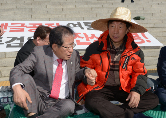 홍준표(왼쪽) 자유한국당 대표가 4일 국회 본청 앞에서 단식농성 중인 김성태 원내대표를 방문해 손을 잡고 격려하고 있다.