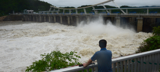 지난 16일부터 3일 연속 내린 폭우로 만수위가 된 경기 하남시 팔당댐이 18일 오전 방류를 시작하고 있다.