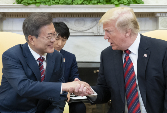문재인 대통령과 도널드 트럼프 미국 대통령이 22일 미국 워싱턴 백악관에서 열린 한·미 정상회담에 앞서 악수를 나누고 있다. 두 정상은 이날 북한 비핵화와 6월 예정된 미·북 정상회담 성사 문제 등을 논의했다.  연합뉴스