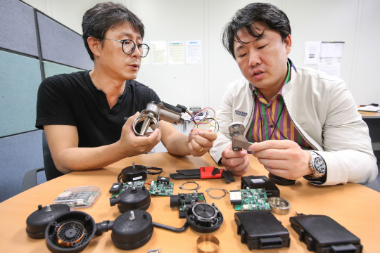 지난 17일 경기 의왕시 현대차 의왕연구소 7층에 마련된 현대기아차 전략기술본부 ‘H스타트업팀’의 사내벤처 중 하나인 ‘아스콘 플러스’의 이상일(왼쪽) 책임연구원과 정우철 책임연구원이 부품들을 손에 들고 토론을 벌이고 있다. 현대차 제공