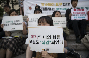 30일 서울 중구 세종대로 서울파이낸스센터 앞에서 열린 집회 참석자들이 최저임금법과 관련해 대통령 거부권 발동을 요구하는 내용의 팻말을 들고 있다. 연합뉴스