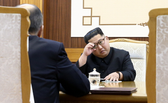 김정은 북한 국무위원장이 평양을 방문한 세르게이 라브로프 러시아 외교장관을 만나 이야기를 나누던 중 안경을 고쳐 쓰고 있다.  타스 연합뉴스