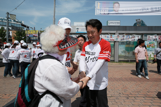 남경필(오른쪽) 자유한국당 경기지사 후보가 3일 경기 평택시 평택역 광장에서 시민과 악수하고 있다.  남경필 후보 선거캠프 제공