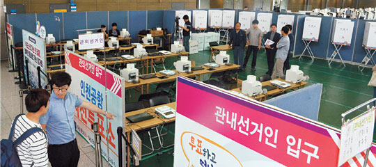 사전투표일을 하루 앞둔 7일 오전 인천공항 제1터미널 출국장에 마련된 사전투표소에서 직원들이 투표 관련 설비를 점검하고 있다.