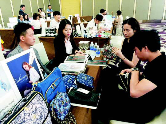 6일 베트남 하노이의 ‘롯데센터 하노이’에서 열린 제3회 해외시장 개척단, 현지 바이어 구매 상담회에서 베트남 바이어들(오른쪽)이 루바니의 가방 제품들을 꼼꼼히 살펴보고 있다.