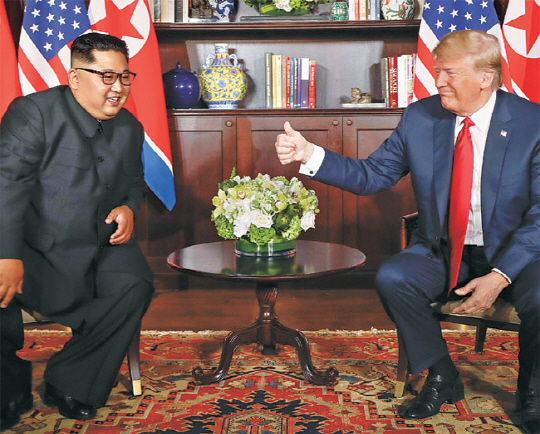 도널드 트럼프(오른쪽) 미국 대통령이 12일 미·북 정상회담이 열린 싱가포르 센토사섬 카펠라 호텔 내 회담장에서 김정은 북한 국무위원장과 인사말을 나누던 중 엄지를 들어 보이고 있다.  AP연합뉴스