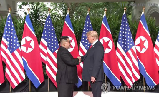 (싱가포르=연합뉴스) 역사적 첫 북미정상회담이 열린 12일 오전 싱가포르 센토사 섬 카펠라호텔에서 미국 도널드 트럼프 대통령과 북한 김정은 국무위원장이 북미정상회담에 앞서 악수하고 있다. [스트레이츠타임스 홈페이지 캡처=연합뉴스]