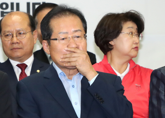 홍준표 자유한국당 대표가 13일 서울 여의도 당사에서 TV를 통해 6·13 지방선거 출구조사 결과를 시청하던 중 낙담한 표정을 감추려는 듯 손으로 입을 가리고 있다.  연합뉴스