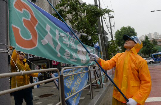 14일 오전 서울 종로구 일대에서 종로구청 직원들이 선거 현수막을 철거하고 있다.