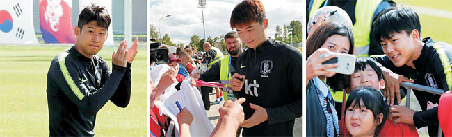 13일 밤(한국시간) 축구대표팀의 베이스캠프인 러시아 상트페테르부르크의 스파르타크스타디움에서 손흥민(토트넘 홋스퍼·왼쪽)이 팬들의 응원에 박수로 화답하고 있다. 기성용(스완지시티·가운데)은 사인을 해주고, 이승우(헬라스 베로나·오른쪽)는 사진촬영에 응하고 있다.  뉴시스 연합뉴스 AP뉴시스