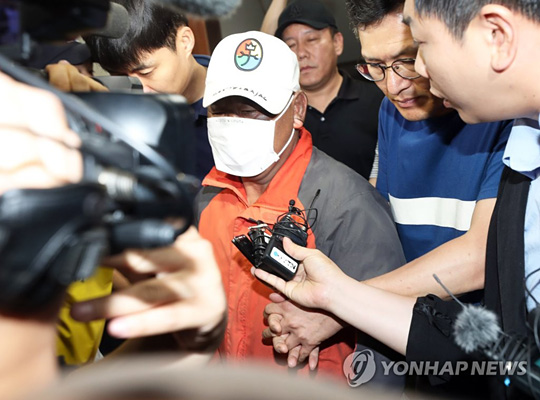 (군산=연합뉴스) 최영수 기자 = 전북 군산시 장미동 한 주점에 불을 지른 혐의로 긴급체포된 이모(55)씨가 18일 새벽 병원 치료를 받기 위해 군산경찰서를 나가고 있다.