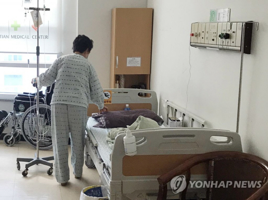 지난 1월 26일 경남 밀양시 가곡동 세종병원에서 발생한 화재 사건 당시 환자를 구조하는 과정에서 연기를 들이마셔 치료 중인 한 요양보호사가 입원한 병원에서 침상을 정리하고 있다. 연합뉴스