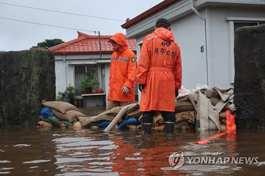 (서귀포=연합뉴스) 많은 장맛비가 내려 서부를 제외한 제주도 전역에 호우특보가 발효된 30일 서귀포시 성산읍 오조리의 한 주택가가 침수돼 소방당국이 배수 작업을 벌이고 있다.