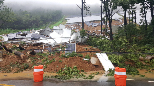 제7호 태풍 ‘쁘라삐룬’의 영향으로 호우가 내린 3일 오전 경북 청도군 매전면 한 태양광발전 설치지역에서 산사태가 발생해 흙이 도로를 덮고 태양광 패널이 부서져 있다.  청도군 제공