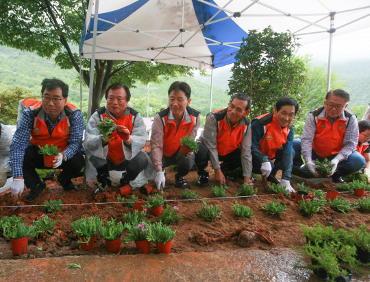 지난달 30일 경남 고성군 상리면 동산마을 마을회관 한편에서 양진석(왼쪽부터) 농협 고성군지부장, 채권석 전 농협중앙회 감사국장, 허식 부회장, 구봉현 전 경남본부장, 곽근영 새고성농협조합장, 강재환 재경고성향우회장이 화단에 꽃을 심고 있다.  농협중앙회 제공
