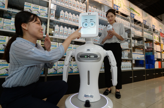 지난 17일 경기 성남시 분당구 암웨이 브랜드 센터에서 SK C&C가 만든 인공지능(AI) 서비스 에이브릴이 적용된 로봇 ‘드리미’가 고객들에게 매장 내 제품을 소개하고 있다.