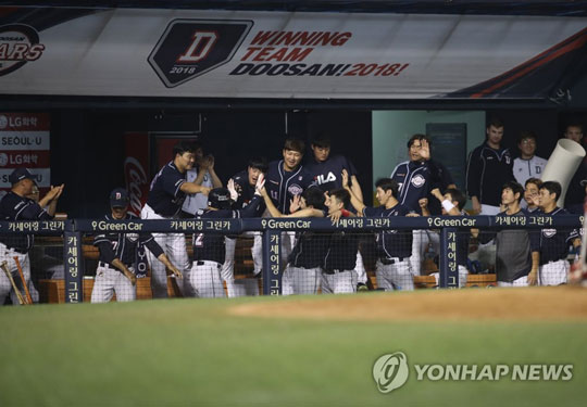 (서울=연합뉴스) 20일 서울 잠실야구장에서 열린 프로야구 두산과 LG의 경기. 12회초 무사 1,2루 에서 두산 오재원의 1타점 적시타 때 홈인한 김재환이 동료의 축하를 받고 있다. 2018.7.20