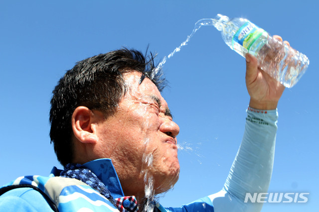 【화천=뉴시스】1일 오후 강원 화천 북한강 쪽배축제장에서 열린 화천군청 공무원 용선경주대회를 마친 공무원이 얼굴에 물을 뿌리며 더위를 식히고 있다. 이날 오후 홍천 기온이 40.6도까지 치솟으며 우리나라 기상관측 역대 최고 온도를 기록했다. 2018.08.01.