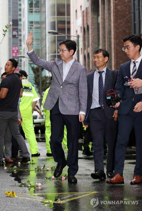 (서울=연합뉴스) 김경수 경남도지사가 드루킹의 댓글조작 행위를 공모한 혐의로 6일 오전 서울 강남구 특검에 출석, 지지자들을 향해 손을 흔들고 있다. 특검은 김 지사가 2016년 11월 드루킹이 운영한 경기도 파주 느릅나무 출판사를 찾아 이른바 ‘킹크랩 시연회’를 참관하고 댓글조작을 지시했다고 보고 있다. 2018.8.6