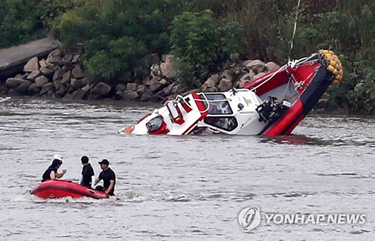 (김포=연합뉴스) 13일 오후 경기도 김포시 고촌읍 신곡수중보 인근 강가에서 전복된 소방구조대 보트가 인양되고 있다. 이곳에서는 전날 오후 1시 33분께 “민간보트가 신곡수중보에 걸려 있다”는 신고를 접수하고 출동한 A(37) 소방장과 B(37) 소방교 등 2명이 보트 전복사고로 실종됐다.