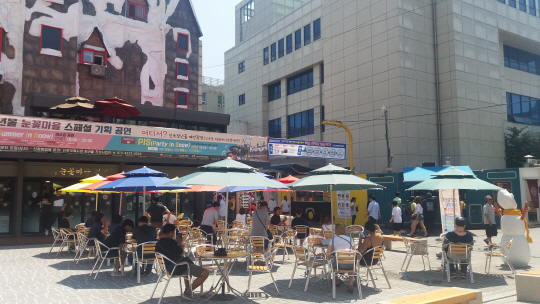 지난 8일 인천 중구 신포국제시장의 청년몰 ‘눈꽃마을’ 광장에서 손님들이 휴식을 취하고 있다. 폭염이 맹위를 떨친 평일인데도 상당수의 손님이 눈에 띈다.