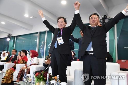 (자카르타=연합뉴스) 이낙연 국무총리와 북한 리룡남 내각 부총리가 18일 오후(현지시간) 인도네시아 자카르타 겔로라 붕 카르노(GBK) 스타디움에서 열린 2018 자카르타·팔렘방 아시안게임 개회식에서 남북단일팀이 공동 입장하자 손을 맞잡고 반기고 있다. 2018.8.19