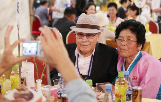 제21차 이산가족 상봉행사 1회차 둘째 날인 21일 북한 금강산호텔에서 열린 단체상봉에서 남측 유관식(89) 할아버지가 딸 유연옥(67) 씨와 사진을 찍고 있다.  연합뉴스