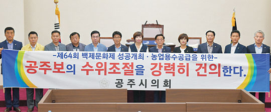 23일 충남 공주시의회 시의원 12명 전원이 금강 공주보 개방 중단을 촉구하는 결의안을 채택한 뒤 본회의장에서 관련 주장을 담은 플래카드를 들고 있다.  공주시의회 제공