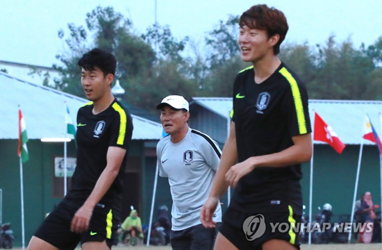 (자카르타=연합뉴스) 2018 자카르타-팔렘방 아시안게임에 출전 중인 축구 국가대표팀 김학범 감독(가운데)이 25일 오후(현지시간) 인도네시아 자카르타 인근 라판간의 훈련장에서 몸을 풀며 족구 게임을 하는 손흥민(왼쪽)과 황의조의 모습을 바라보고 있다.