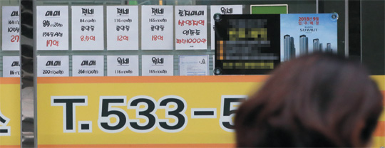 정부의 투기지역·투기과열지구·조정대상지역 추가 지정을 앞둔 지난 23일 서울 한 공인중개업소 앞을 행인이 지나가고 있다.  연합뉴스