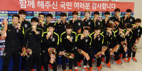 2018 자카르타-팔렘방아시안게임에서 우승한 남자축구 대표팀이 3일 오전 인천공항에 도착한 뒤 금메달을 깨물며 포즈를 취하고 있다. 한국 남자축구는 아시안게임 2연패를 달성했고 처음으로 원정 아시안게임 금메달을 획득했다. 김동훈 기자 dhk@