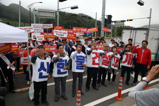 지난달 28일 경북 경주 한국수력원자력 본사 앞에서 일부 울진군민이 정부와 한수원의 신한울원자력발전소 3·4호기 건설 중단 방침에 반발해 집회를 열고 구호를 외치고 있다.  연합뉴스