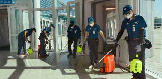 지난 10일 메르스(중동호흡기증후군)로 비상이 걸린 인천국제공항에 마스크를 쓴 검역직원들이 입국 승객통로에 소독약을 뿌리고 있다.