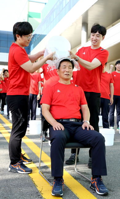 이영호(가운데) 롯데푸드 대표이사가 13일 충남 천안시 차암동 천안공장에서 아이스버킷 챌린지 운동에 참여하기 위해 얼음물을 뒤집어쓰고 있다.  롯데푸드 제공