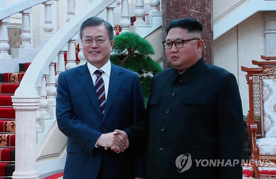 (서울=연합뉴스) 문재인 대통령과 김정은 북한 국무위원장이 18일 평양 조선노동당 중앙위원회 본부청사에서 가진 1차 정상회담에서 악수하는 장면이 서울 DDP 프레스센터에 중계되고 있다. 노동당사에서의 남북 정상회담은 이번이 처음이다. 2018.9.18