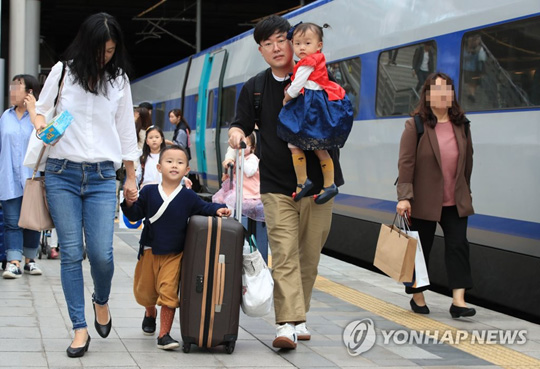 (서울=연합뉴스) 추석 연휴 시작을 하루 앞둔 21일 오후 서울역에서 귀성객들이 밝은 표정으로 열차로 향하고 있다.