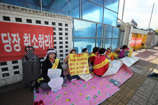 1일 서울 강동구 성내동 서울상운차량공업 부지 앞에서 지역 주민들이 역세권 임대주택 사업 계획을 취소하라며 연좌시위를 하고 있다.  연합뉴스