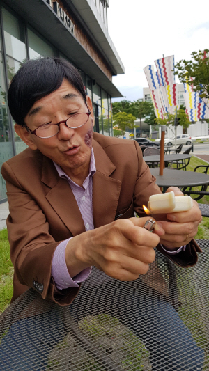 전순호 ‘호보’ 대표가 지난 2일 광주 서구 광주광역시청 앞 야외에서 자신이 만든 비누에 라이터로 불을 붙여 화학첨가제가 들어 있지 않다는 점을 입증해 보이고 있다.