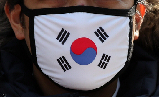 3·1절 99주년인 지난 3월 1일 서울 종로구 구 일본대사관 앞에서 보수 성향 단체 소속 회원이 태극기가 그려진 마스크를 쓰고 있다.  연합뉴스