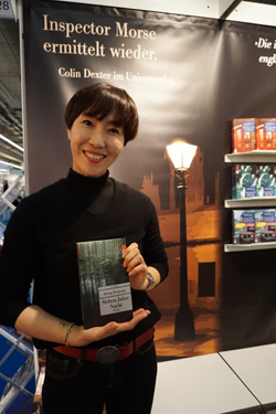 정유정 작가가 10일 ‘7년의 밤’을 출간한 우니온 출판사 부스 앞에서 독일어판을  들어 보이고 있다.