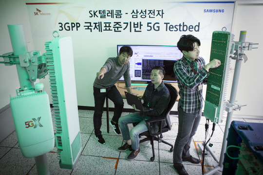 15일 ‘퍼스트 콜(First Call)에 성공한 SK텔레콤과 삼성전자 연구원들이 3.5㎓ 대역 5G 상용 장비를 살펴보고 있다. SK텔레콤 제공
