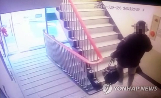 (부산=연합뉴스) 일가족 4명을 살해한 뒤 스스로 목숨을 끊은 것으로 의심받는 30대 남성이 24일 오후 범행장소인 부산 사하구의 한 아파트에 범행도구가 담긴 것으로 추정되는 가방을 들어 들어가는 장면이 아파트 CCTV에 잡혔다. [부산경찰청 제공]