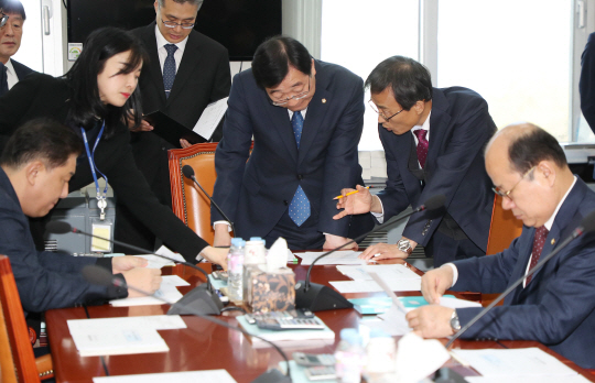 12일 오전 국회에서 열린 국회 국방위원회 예산결산심사소위원회 회의 도중 더불어민주당 소속 민홍철(오른쪽 세 번째) 소위원장이 참석자들과 자료를 검토하고 있다.  연합뉴스