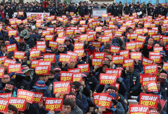 21일 오후 울산 남구 삼산동 동해선 철도 태화강역 광장에서 열린 민주노총 울산 총파업 대회에 참가한 조합원들이 ‘재벌 세상 뒤엎자’ 손팻말을 들고 구호를 외치고 있다. 연합뉴스