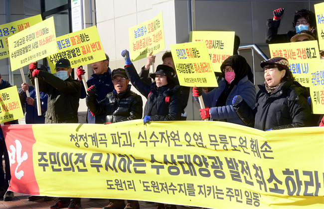 강원 고성군 도원리 주민들이 22일 고성군청 앞에서 열린 도원저수지 수상 태양광 발전시설 설치 반대 집회에서 펼침막과 피켓을 들고 ‘청정계곡 파괴하는 태양광 발전을 취소하라’는 구호를 외치고 있다.