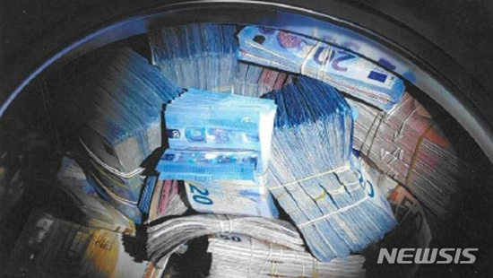 【암스테르담=AP/뉴시스】 네덜란드 암스테르담에서 주택거래 조작을 통해 ‘돈세탁’한 뭉칫돈 35만 유로를 자신의 집에 있는 진짜 세탁기 안에 감춰두었던 24세 남성이 경찰에 체포됐다. 사진은 세탁기 안에서 발견된 20유로짜리 지폐와 50유로짜리 지폐 뭉치로 암스테르담 경찰이 보도자료를 통해 제공한 것이다. 2018.11.23