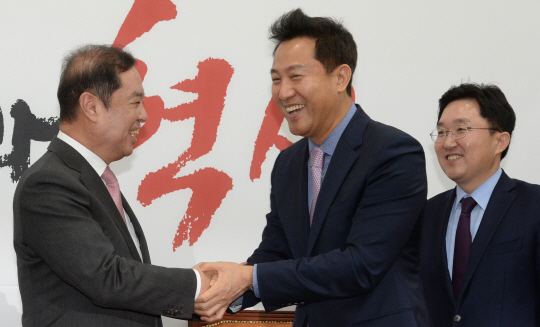 오세훈(가운데) 전 서울시장이 29일 오전 국회에서 진행된 자유한국당 입당식에서 김병준 비대위원장과 악수하고 있다. 오른쪽은 김용태 사무총장. 김호웅 기자 diverkim@