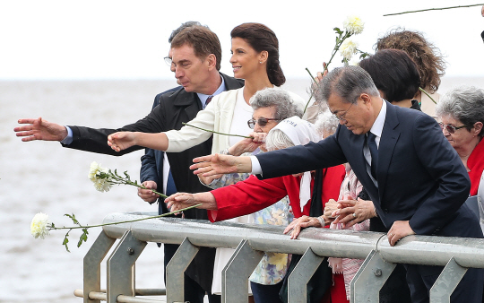 문재인 대통령이 29일 주요 20개국(G20) 정상회의 참석차 방문한 아르헨티나 부에노스아이레스의 라플라타 강변 국립역사기념공원에서 아르헨티나 군부독재 당시 희생자들을 기리는 유족 모임인 ‘5월 광장 어머니회’ 소속 회원들과 함께 헌화하고 있다.   연합뉴스