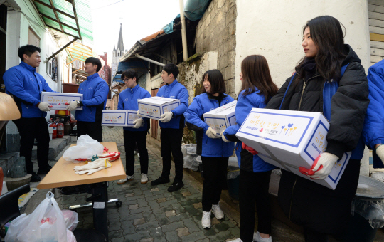 삼성 주요 계열사 임직원들이 5일 오전 서울 종로구 창신동 동신교회 앞에서 ‘쪽방 밀집촌’에 거주하는 주민들에게 생필품 상자를 전달하고 있다.  김동훈 기자 dhk@